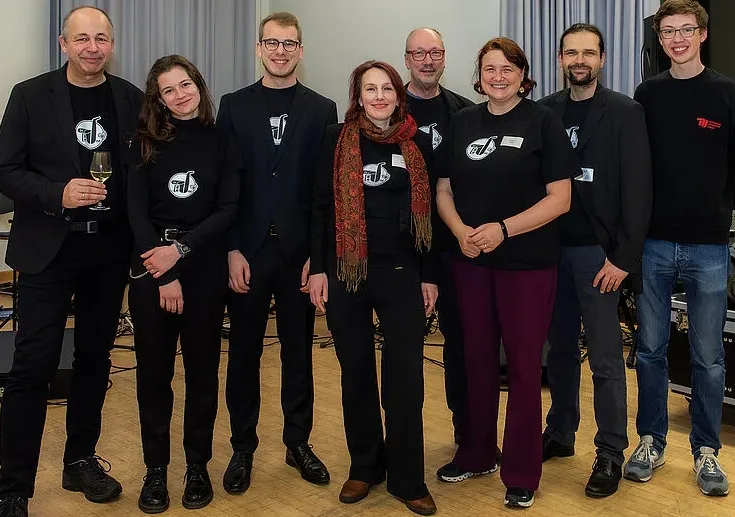 Gruppenfoto des Ensembles in schwarzen AS&T-T-Shirts